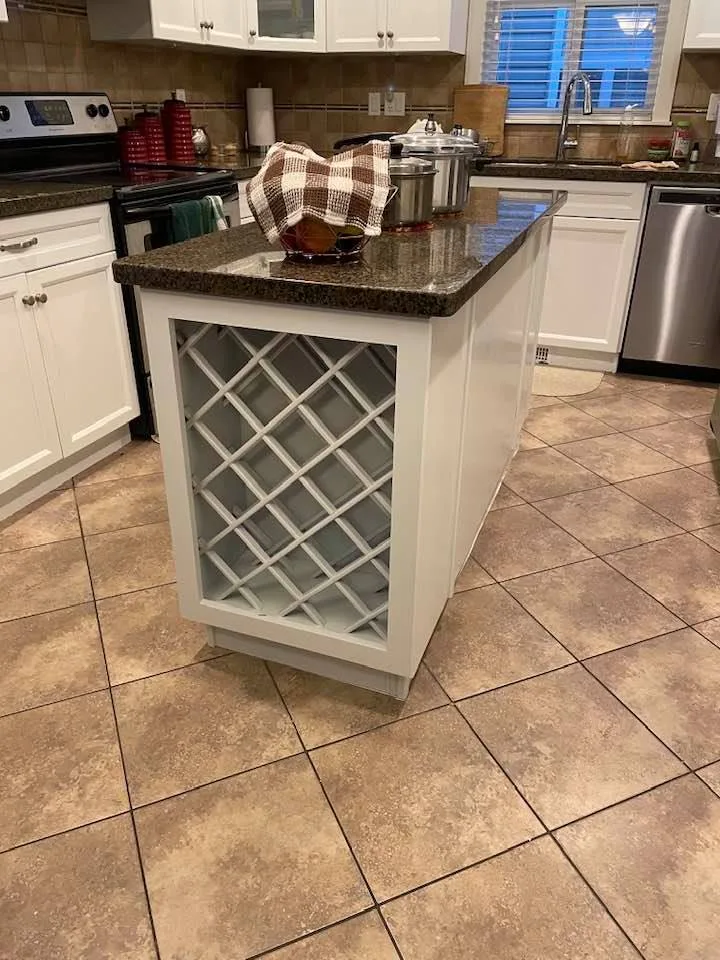 White painted kitchen island cabinets with a built-in wine rack by Johhan Painting