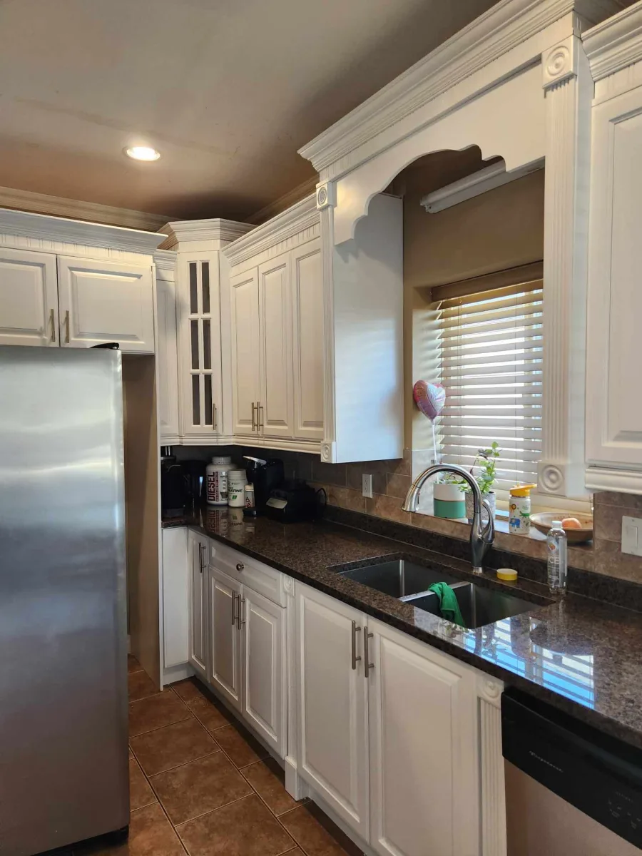 White painted kitchen cabinets with dark granite countertops by Johhan Painting
