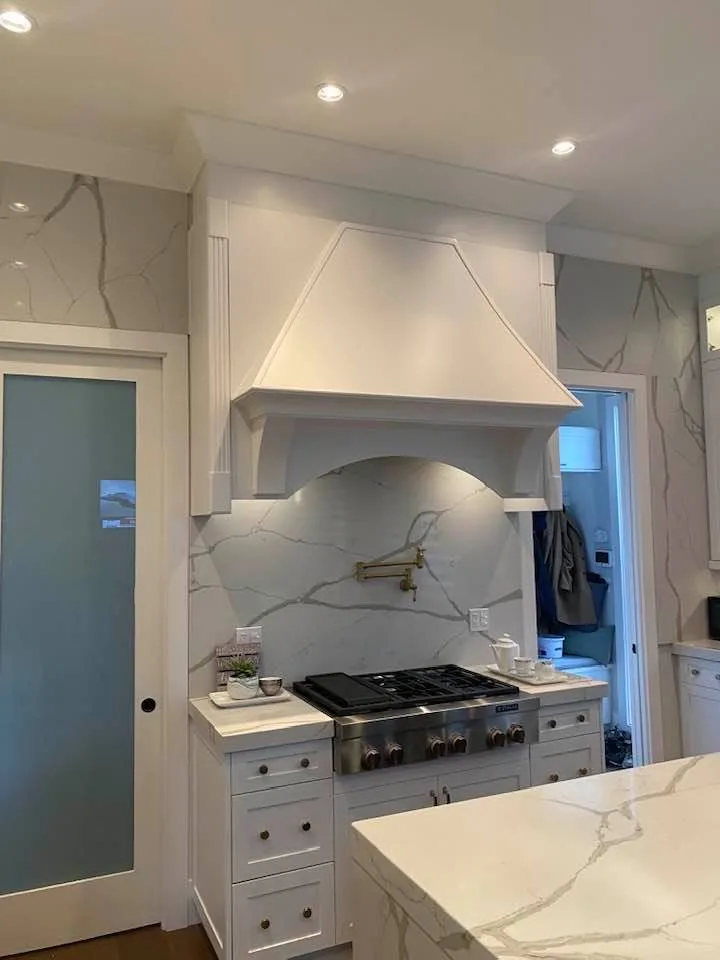 White painted kitchen cabinets and range hood by Johhan Painting