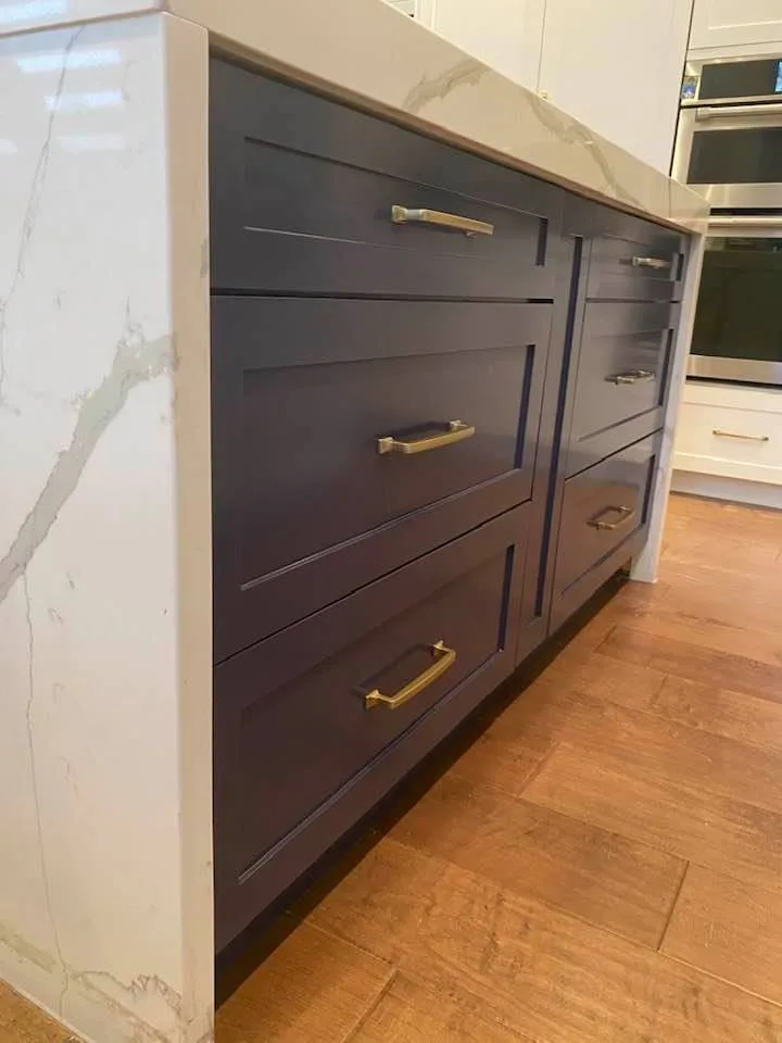 Navy blue painted kitchen island cabinets with brass handles by Johhan Painting
